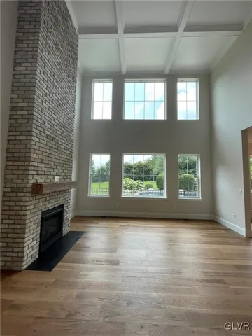a view of an empty room with a fireplace and window