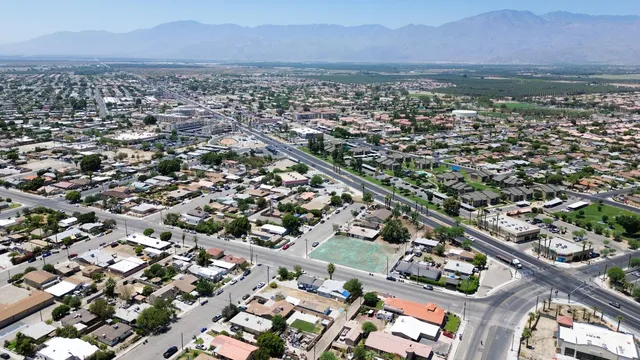 an aerial view of a city with lots of residential buildings and mountain view in back