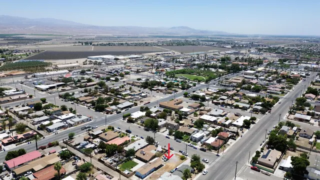 an aerial view of a city with lots of residential buildings and mountain view in back