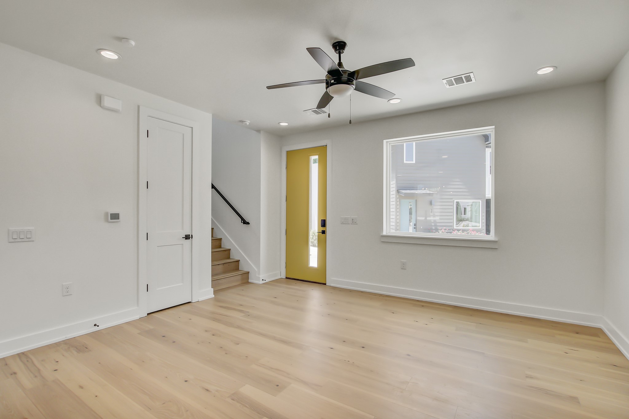 4127 East 12th Street, Unit 8 Austin, TX 78721 - Photo 9 of 32 a view of an empty room with wooden floor and a ceiling fan