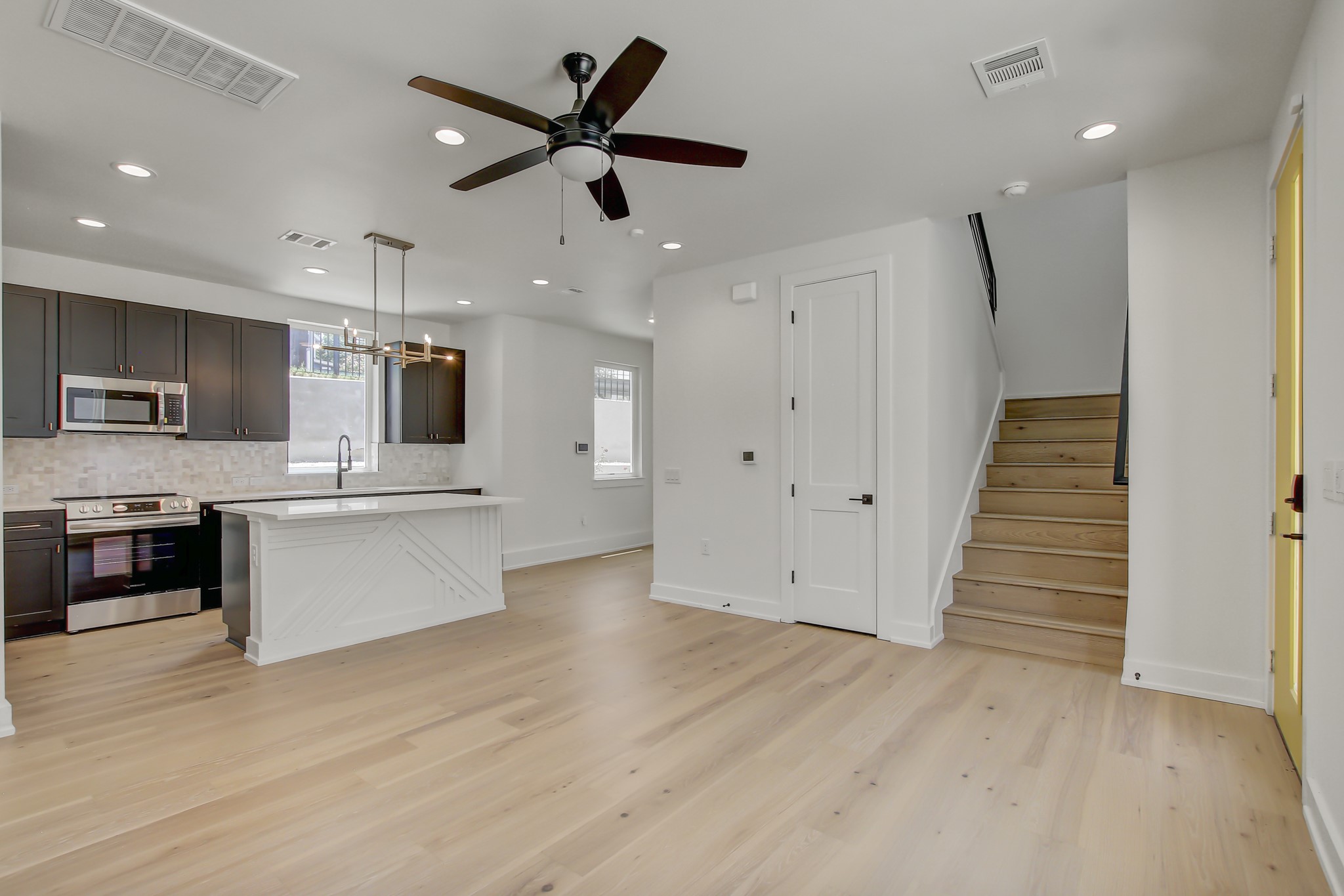 4127 East 12th Street, Unit 8 Austin, TX 78721 - Photo 10 of 32 a large kitchen with stainless steel appliances kitchen island granite countertop a stove and a wooden floors