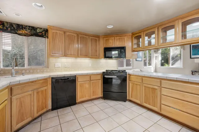 a kitchen that has a sink a stove and a refrigerator