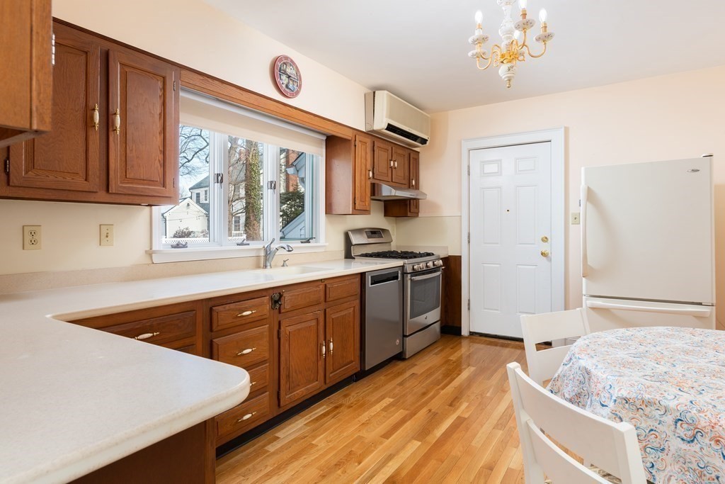 7 Gordon Road Milton, MA 02186 - Photo 8 of 17 a kitchen with stainless steel appliances granite countertop a sink dishwasher stove and refrigerator with wooden floor