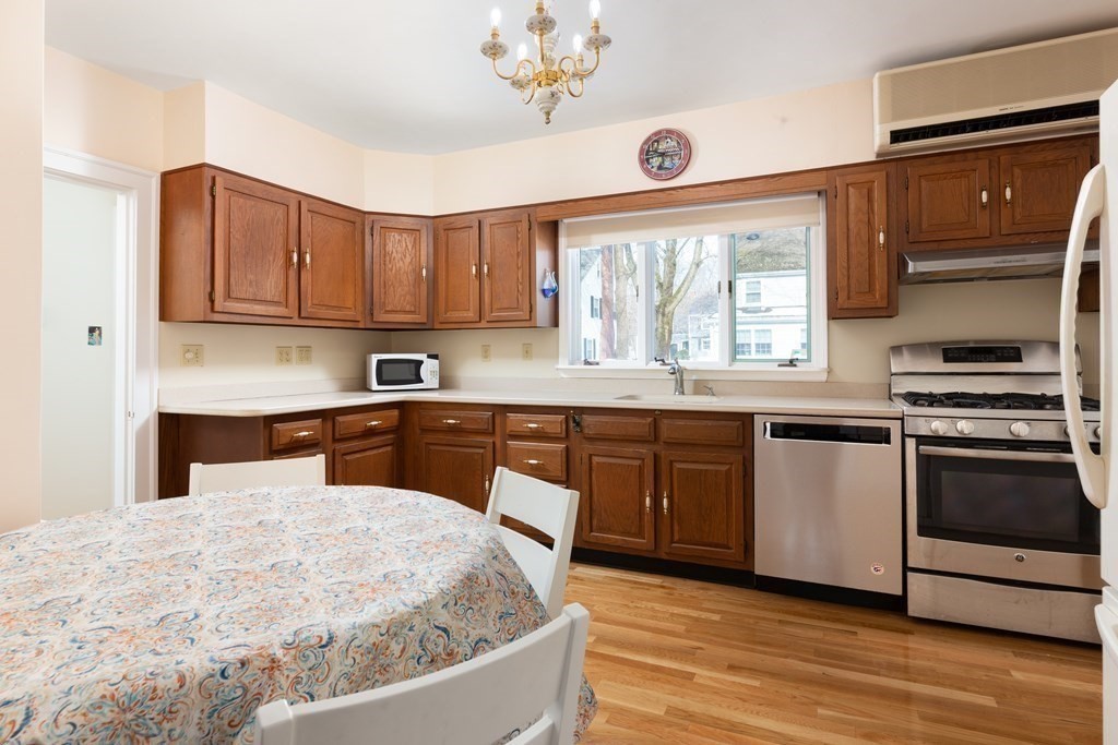 7 Gordon Road Milton, MA 02186 - Photo 9 of 17 a kitchen with stainless steel appliances granite countertop a sink a microwave cabinets and a dining table