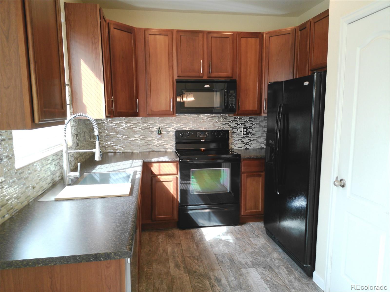 4714 ROWLAND Heights Colorado Springs, CO 80923 - Photo 12 of 41 a kitchen with granite countertop stainless steel appliances a refrigerator and a sink