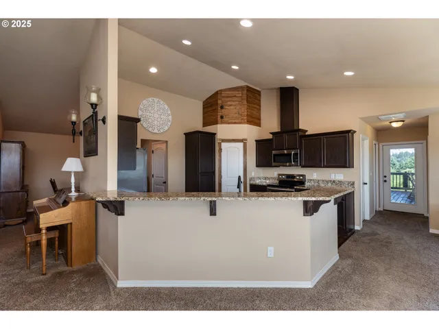 a kitchen with stainless steel appliances kitchen island a sink table and chairs