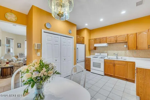 a large kitchen with stainless steel appliances a sink stove and cabinets