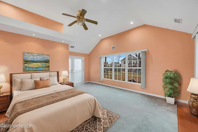 a bedroom with a large bed and a chandelier