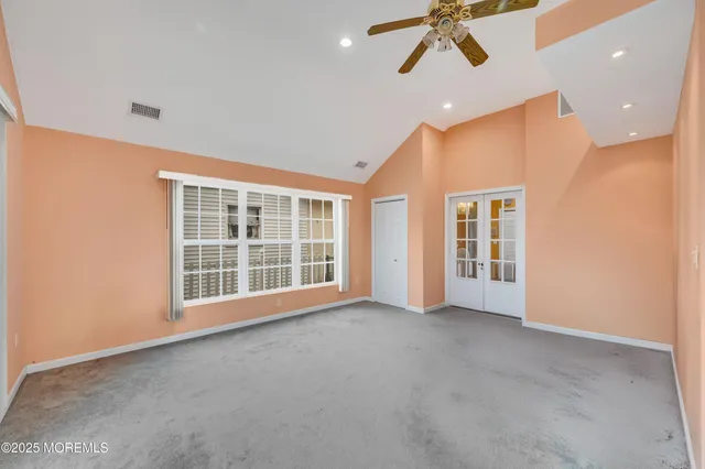 a view of an empty room with a window and kitchen view