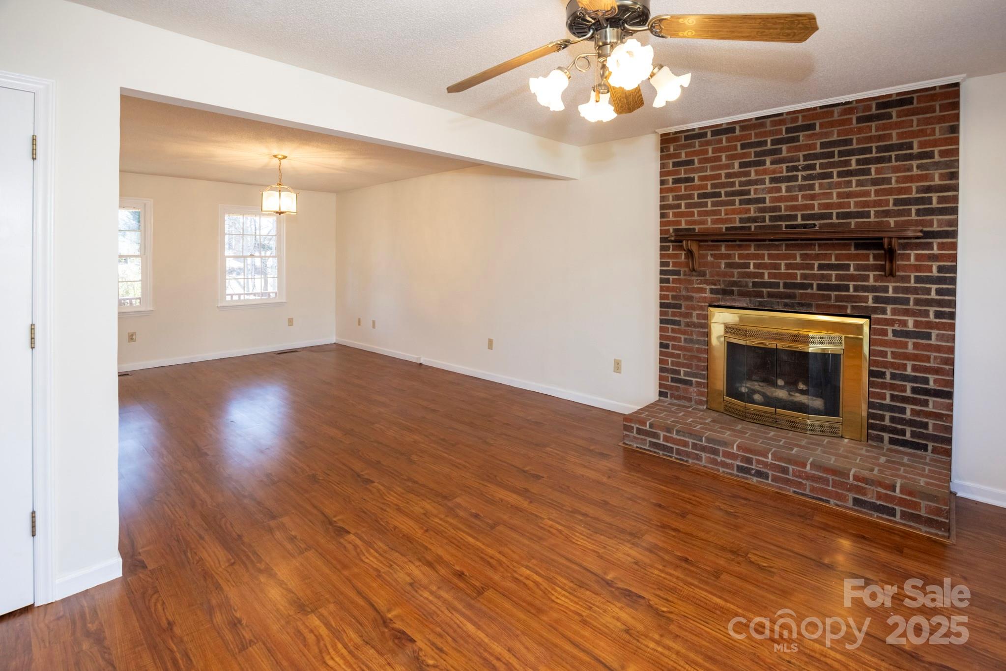 395 Thompson Road Rutherfordton, NC 28139 - Photo 5 of 25 a view of empty room with wooden floor and fireplace