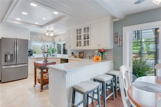 a kitchen with a table chairs refrigerator and a large window