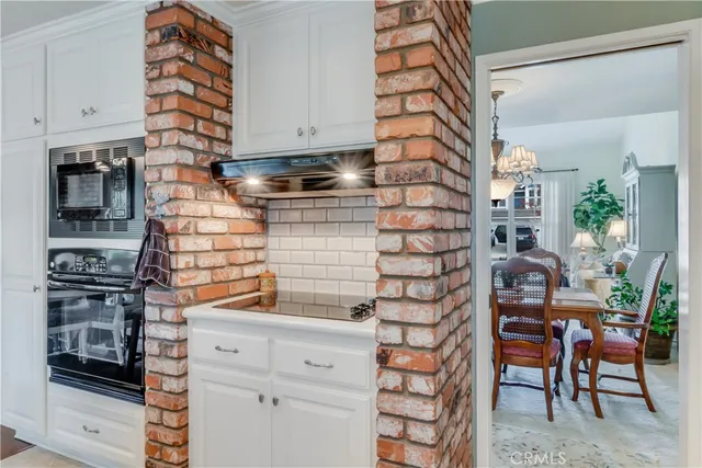 a kitchen with white cabinets and appliances
