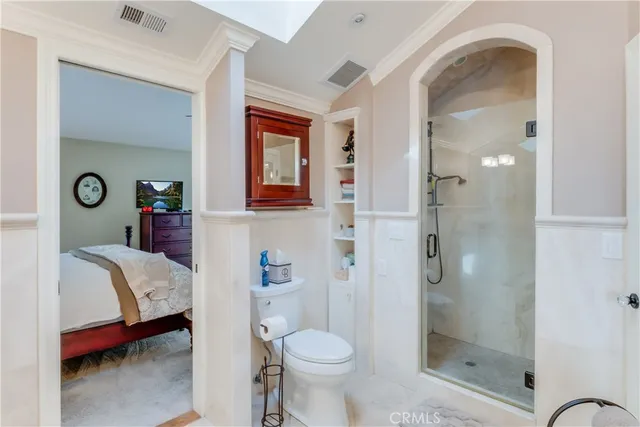 a bathroom with double vanity sinks a toilet a shower a vanity and a mirror