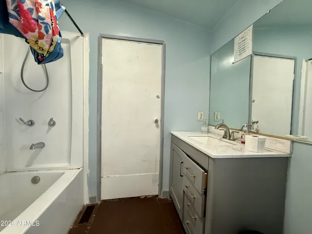 a bathroom with a tub sink and mirror
