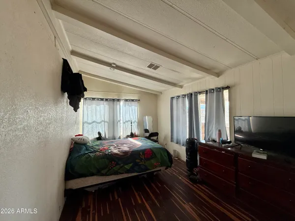 a bedroom with a bed and flat screen tv