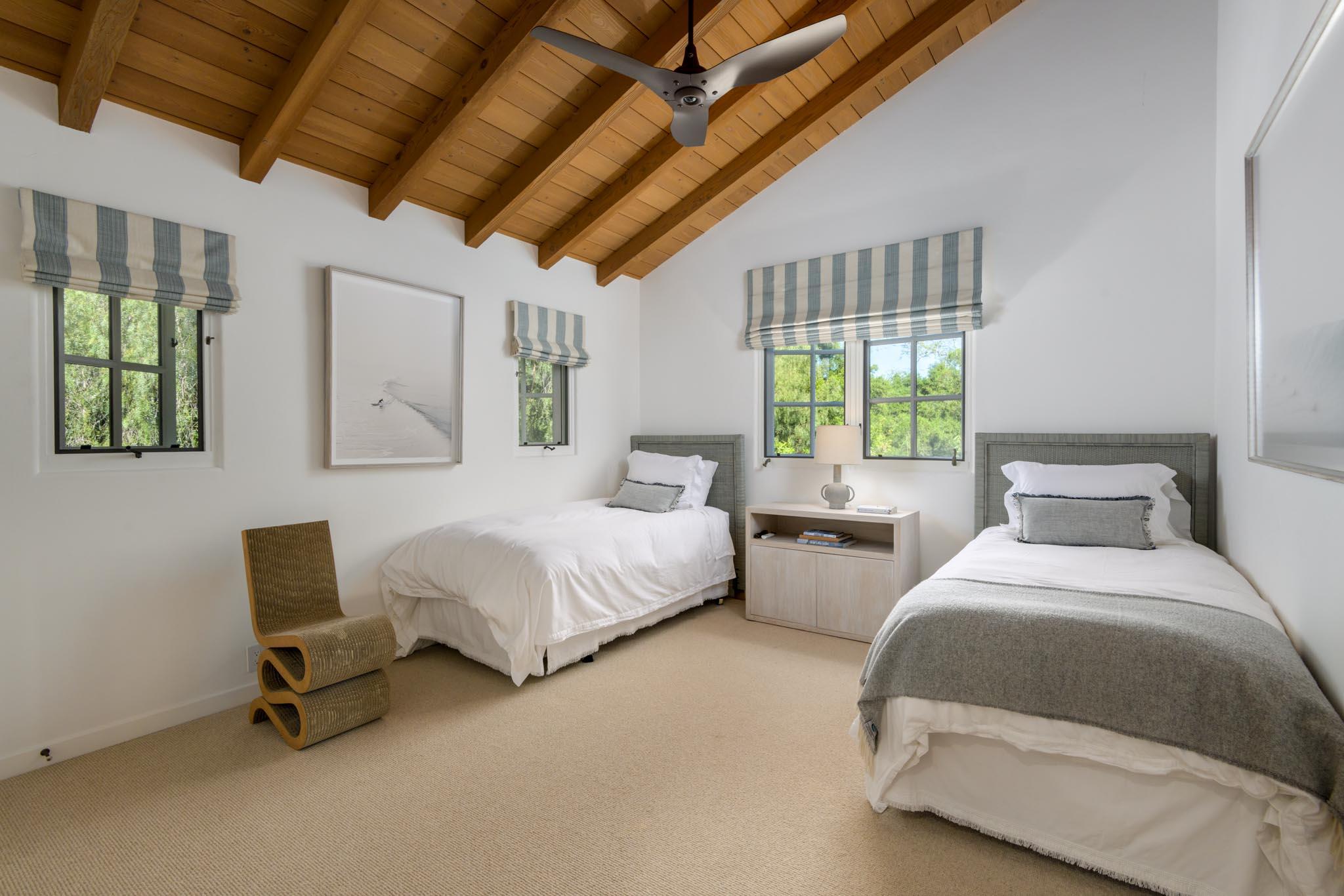849 Ashley Road Montecito, CA 93108 - Photo 17 of 28 a spacious bedroom with two beds and a chandelier