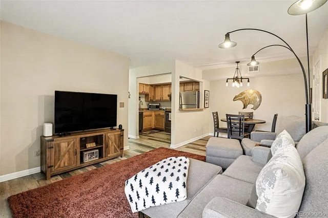 a living room with furniture a flat screen tv and view of kitchen