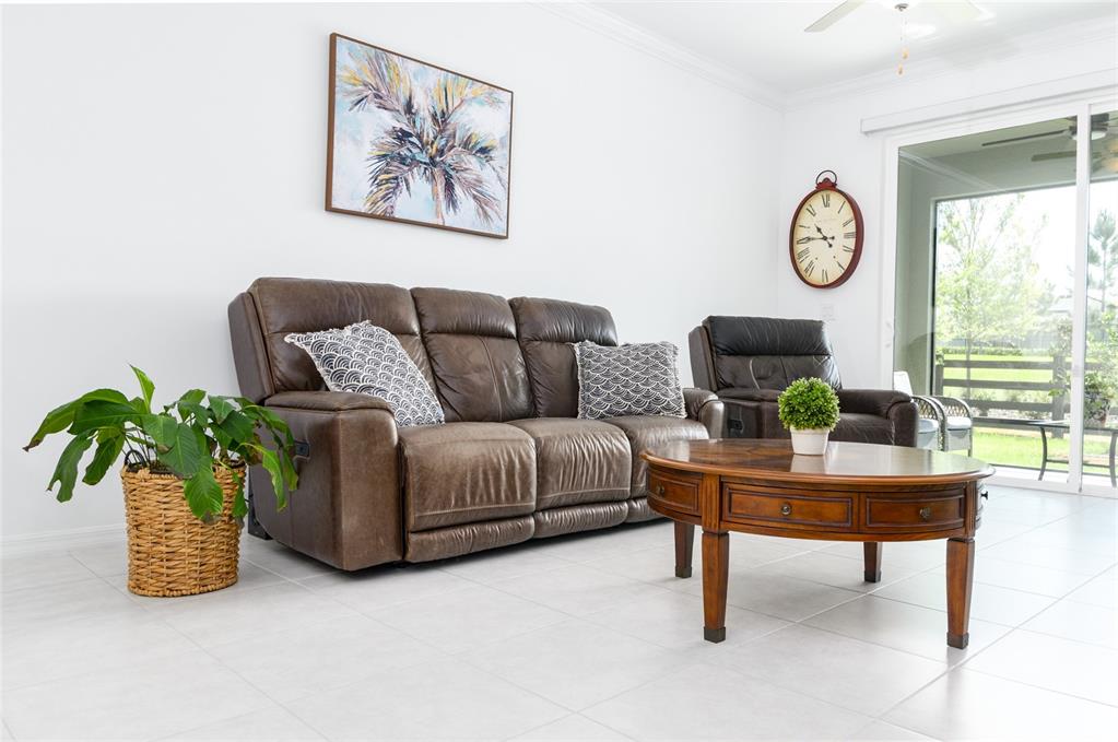 6736 Ripple Pond Loop Zephyrhills, FL 33541 - Photo 20 of 40 a living room with furniture a clock and a window
