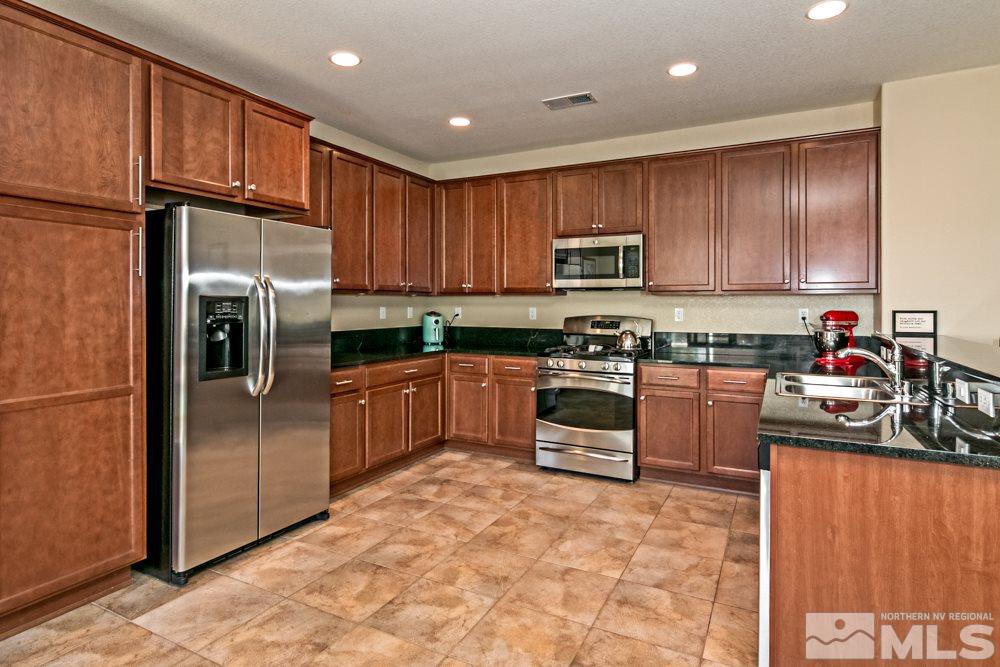 10755 Cedar Rock Drive Reno, NV 89521 - Photo 9 of 22 a kitchen with granite countertop a refrigerator stove top oven and sink
