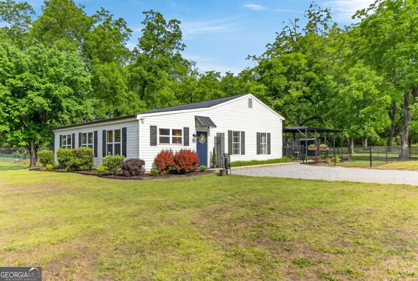 a view of a house with a yard and sitting area