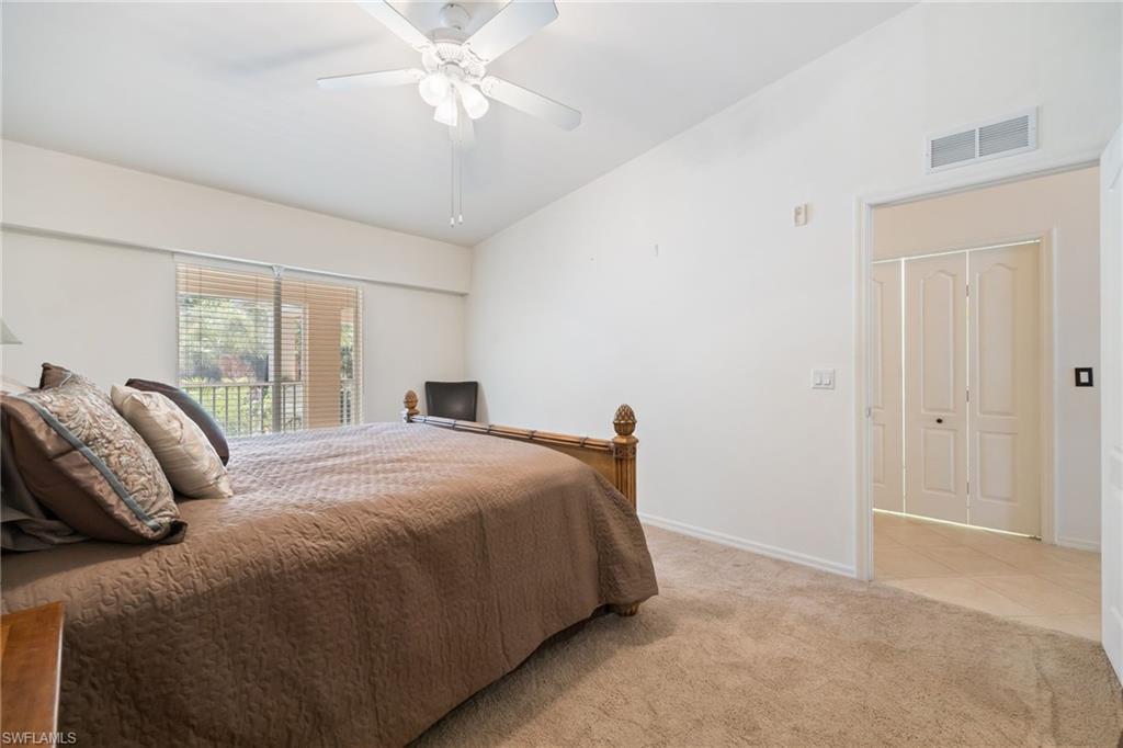 2770 Cypress Trace Circle, Unit 2425 Naples, FL 34119 - Photo 17 of 35 a bedroom with a large bed and a chandelier