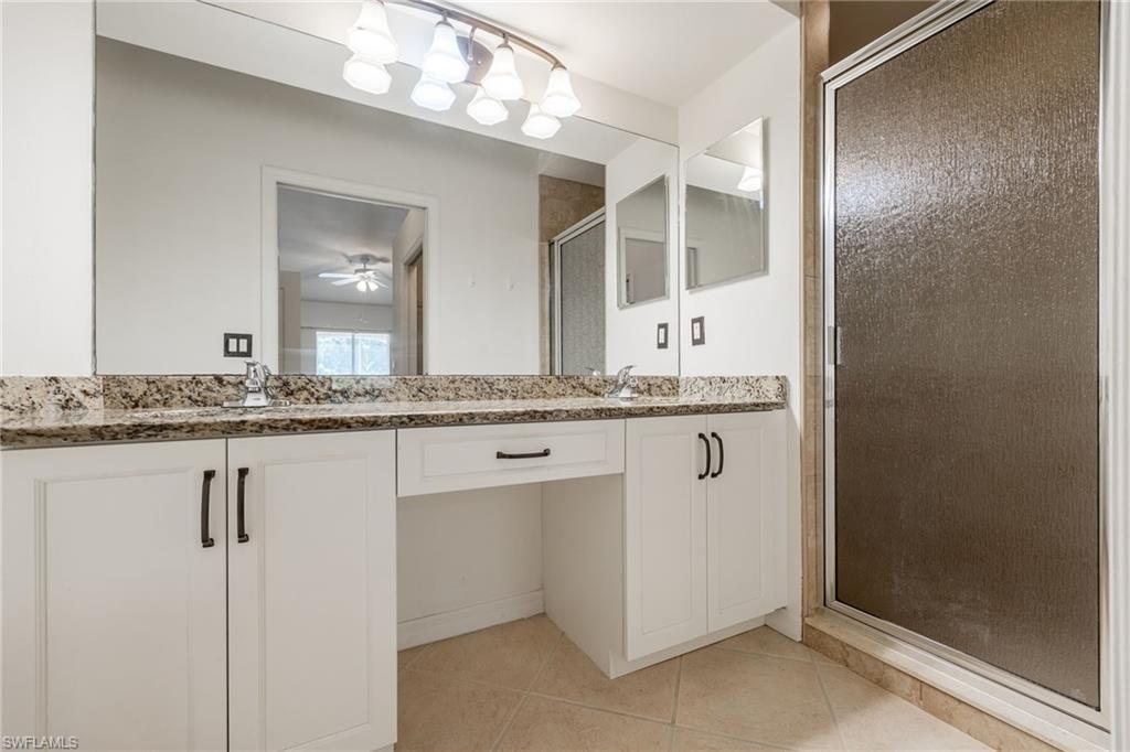 2770 Cypress Trace Circle, Unit 2425 Naples, FL 34119 - Photo 18 of 35 a bathroom with a granite countertop sink and a mirror