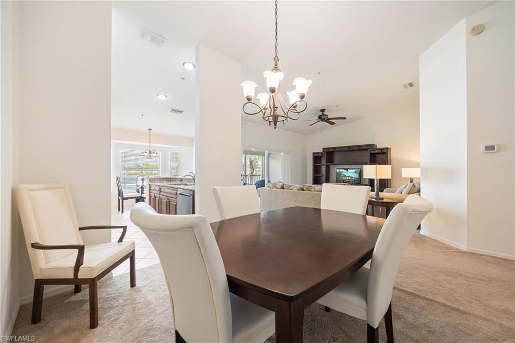 2770 Cypress Trace Circle, Unit 2425 Naples, FL 34119 - Photo 19 of 35 a view of a dining room with furniture a chandelier and wooden floor