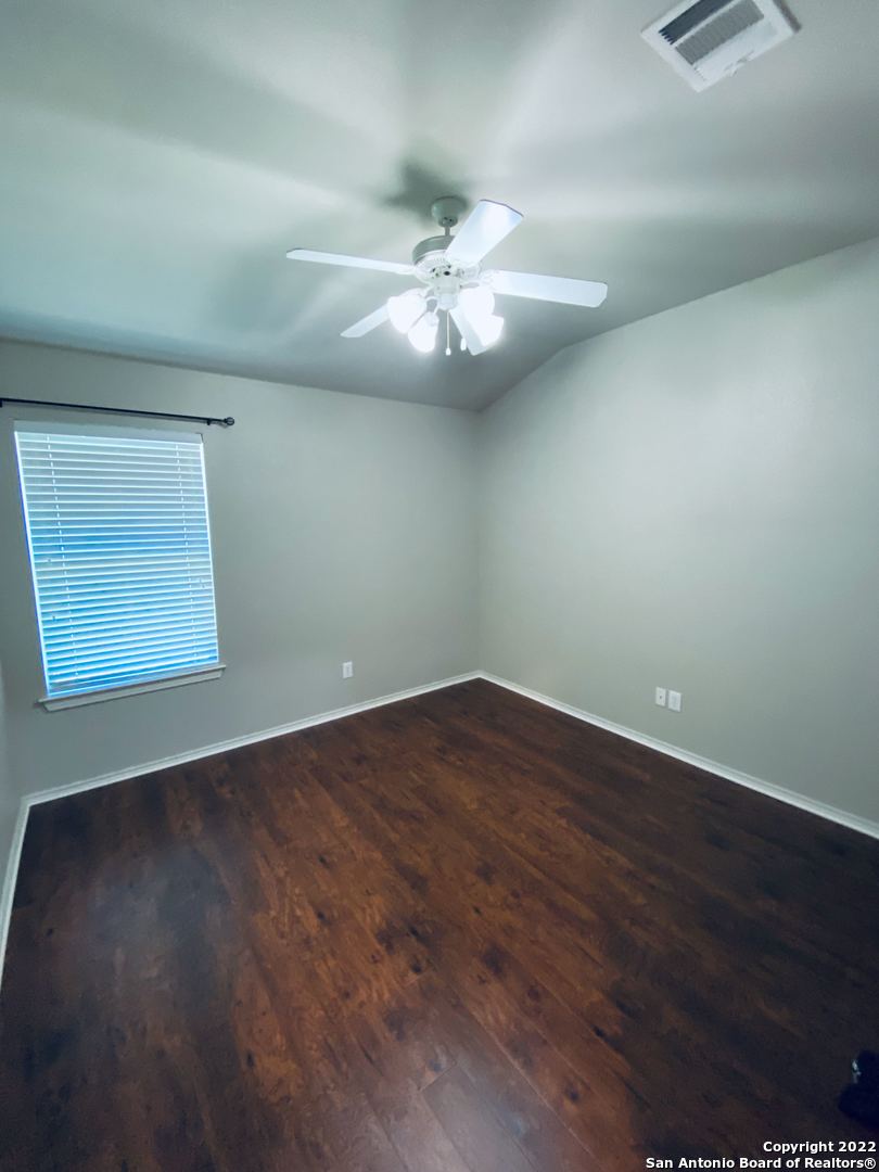707 Point Sunset San Antonio, TX 78253 - Photo 11 of 15 an empty room with wooden floor chandelier fan and windows