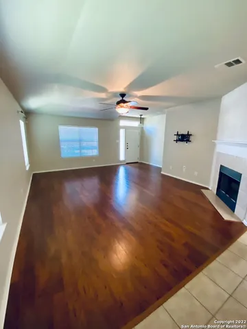 an empty room with wooden floor and fireplace