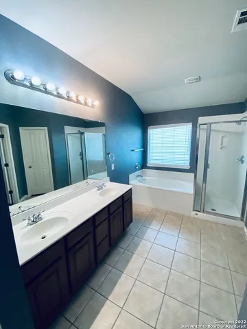 a spacious bathroom with a granite countertop sink a mirror and a bathtub