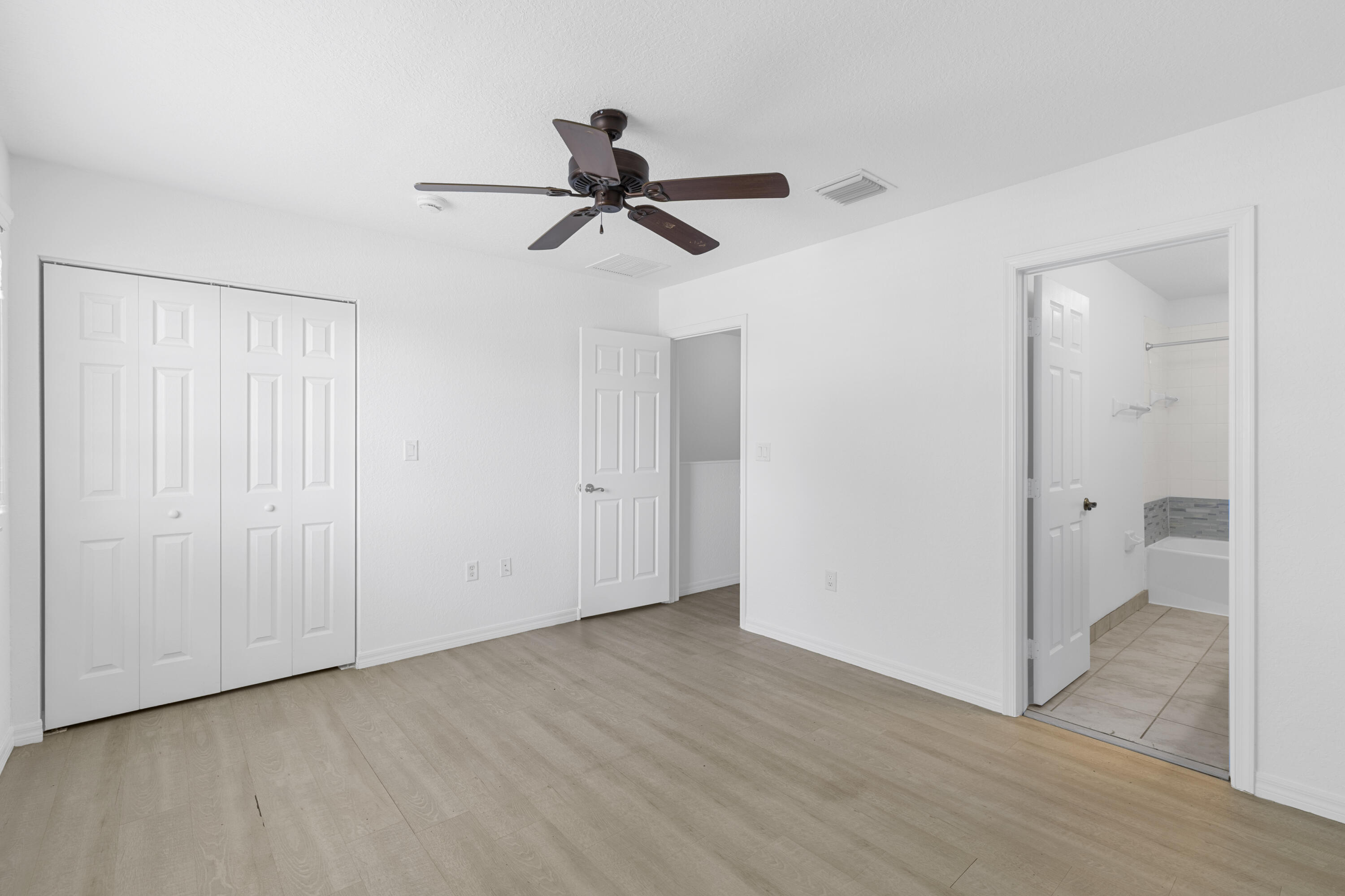 9107 Chambers Street, Unit 9107 Tamarac, FL 33321 - Photo 20 of 30 a view of empty room with wooden floor and ceiling fan
