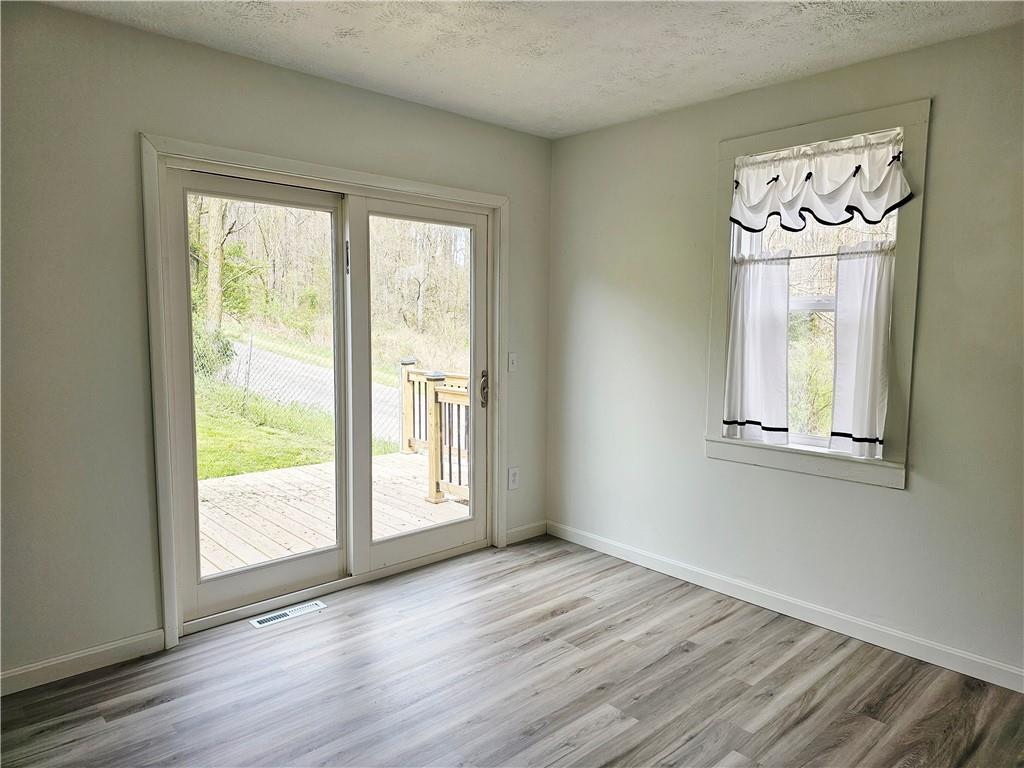 117 Little Rock Road Kittanning, PA 16201 - Photo 10 of 23 a view of an empty room with a window and wooden floor