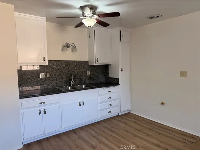 a kitchen with granite countertop white cabinets and stainless steel appliances