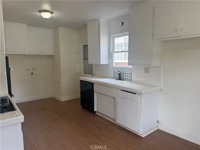 a kitchen with a sink cabinets and a stove top oven