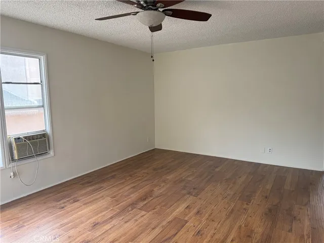 an empty room with a window and wooden floor
