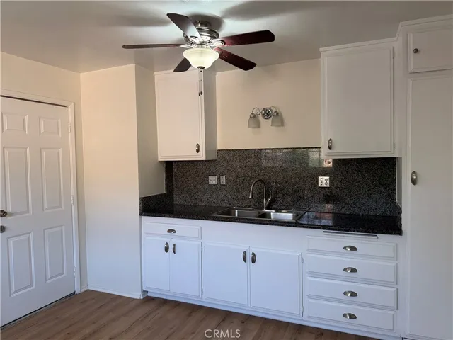 a kitchen with white cabinets a sink and a fireplace