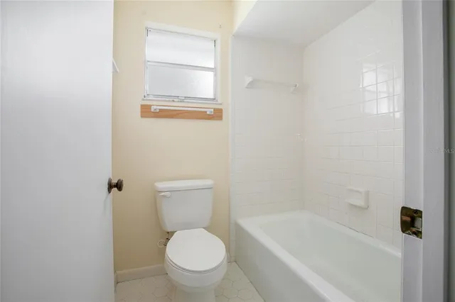 a bathroom with a granite countertop toilet a sink and bathtub
