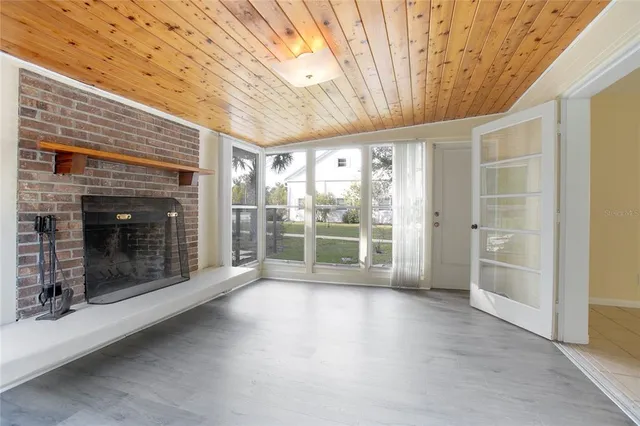 a view of empty room with wooden floor and fireplace