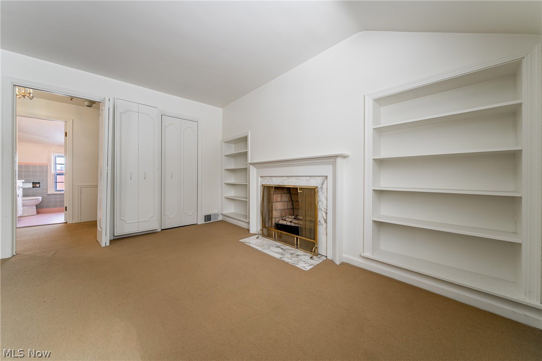 4602 College Road South Euclid, OH 44121 - Photo 19 of 26 Unfurnished living room with light carpet, lofted ceiling, and a fireplace