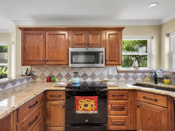 a kitchen with stainless steel appliances granite countertop a sink stove and cabinets