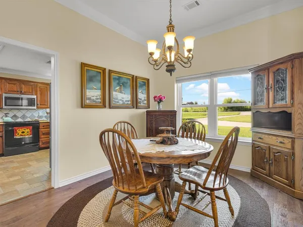 a view of a dining room with furniture a chandelier and wooden floor