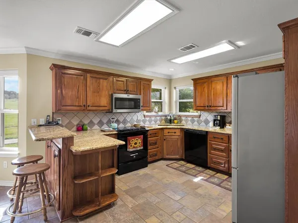 a kitchen with a sink stove top oven and refrigerator