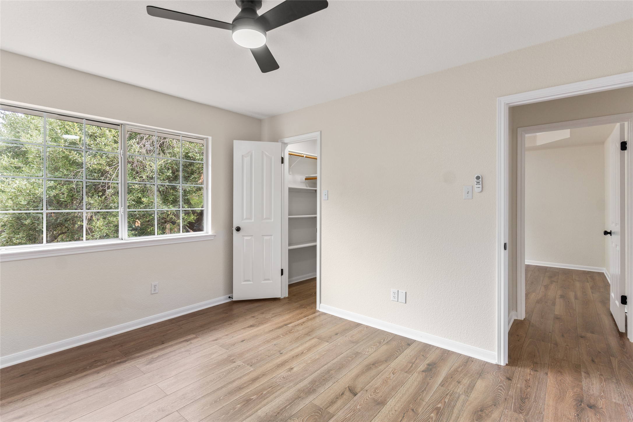 13102 Hunters Chase Drive Austin, TX 78729 - Photo 22 of 39 an empty room with wooden floor and windows