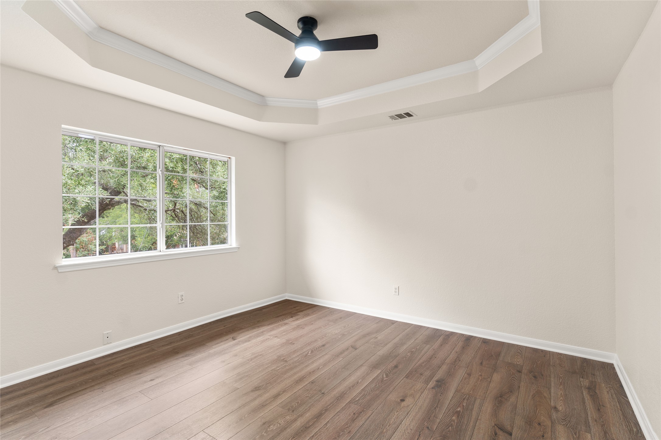 13102 Hunters Chase Drive Austin, TX 78729 - Photo 23 of 39 an empty room with wooden floor and windows