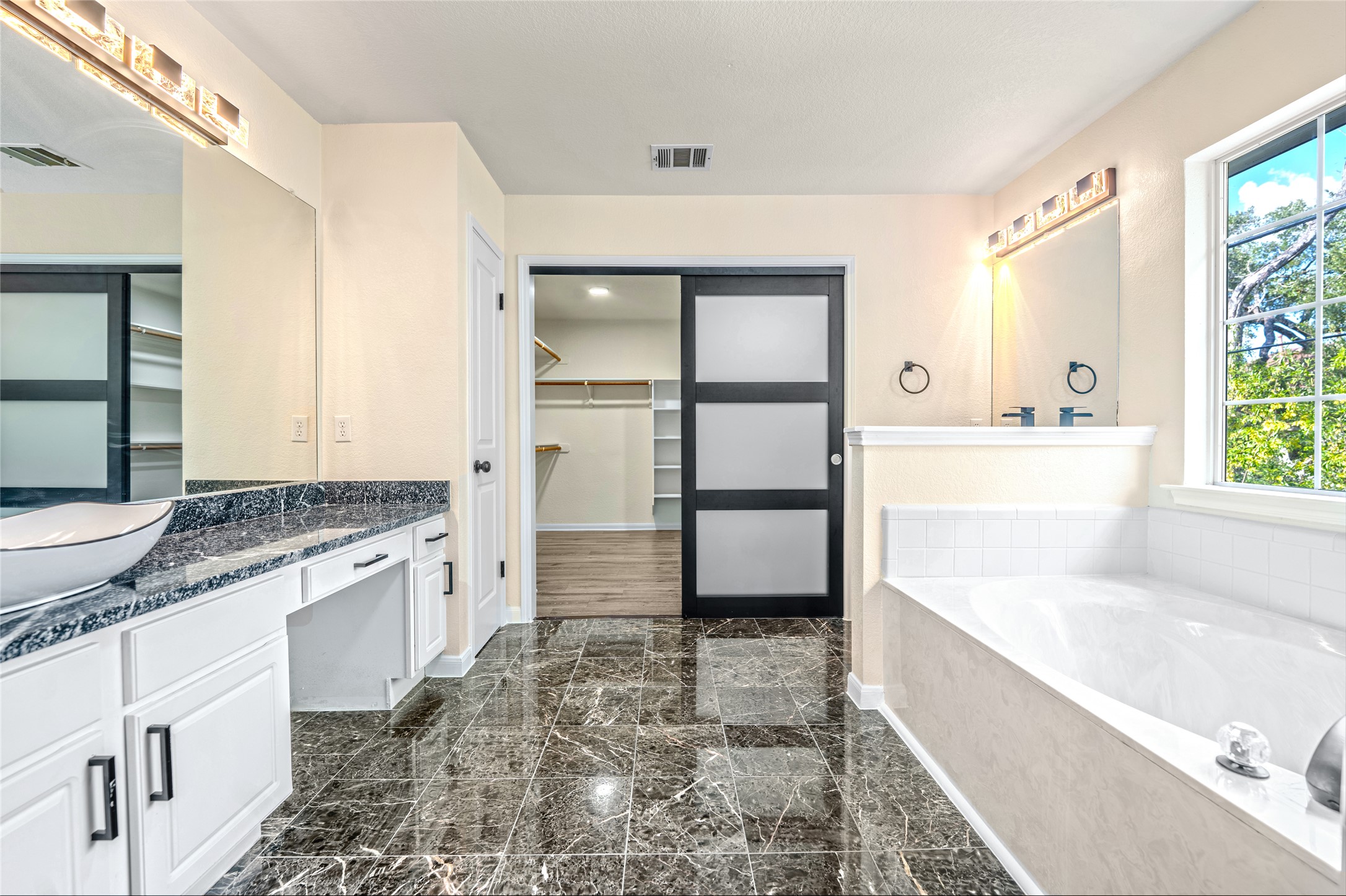 13102 Hunters Chase Drive Austin, TX 78729 - Photo 28 of 39 a bathroom with a granite countertop sink a mirror and a bathtub