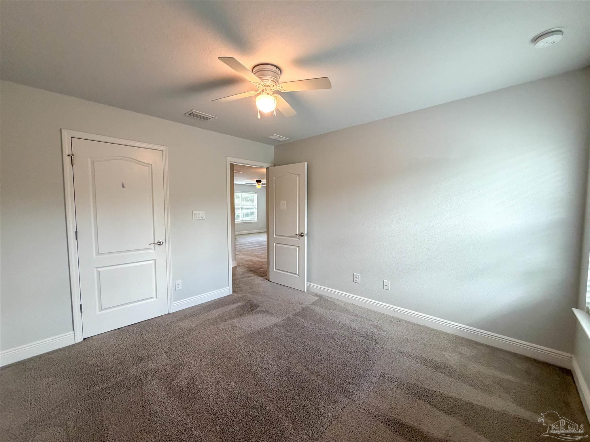 3613 Conley Drive Cantonment, FL 32533 - Photo 24 of 32 an empty room with chandelier fan and windows