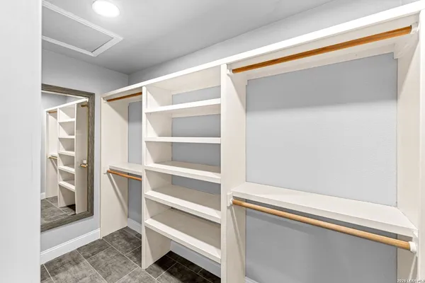 a view of a big room with wooden floor and chandelier fan
