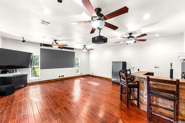 a view of a room with a flat screen tv and a ceiling fan
