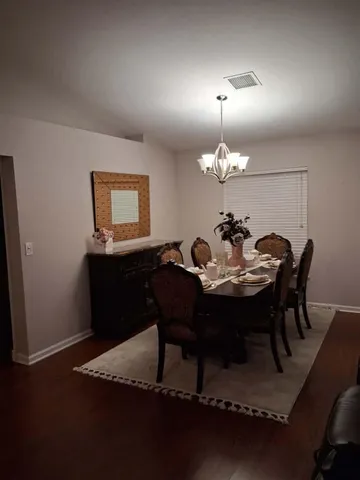 a view of a dining room with furniture and chandelier