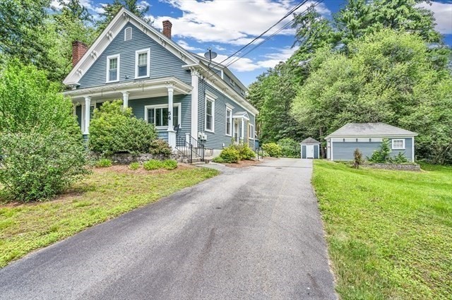 a front view of a house with a yard and trees